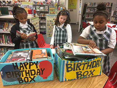 A book donation program can make a child's birthday celebration more meaningful and long-lasting. Girls looking through a box of books in a library