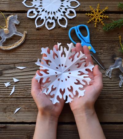 making paper snowflakes with your own hands to spread holiday joy