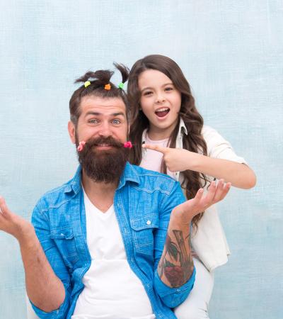 girl pointing and posing with dad after she gives him hilarious hairdo