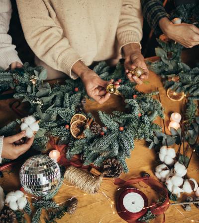 wreath-making hands of women making Christmas wreaths using natural pine branches
