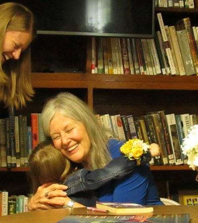 Author Elizabeth Berg hugs a girl at her Meservey Public Library visit