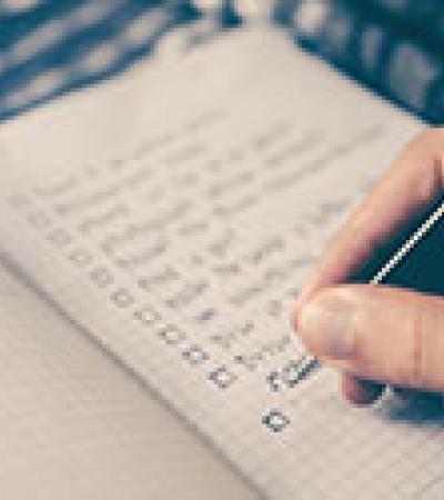 Hand checking off a to-do list in a notebook