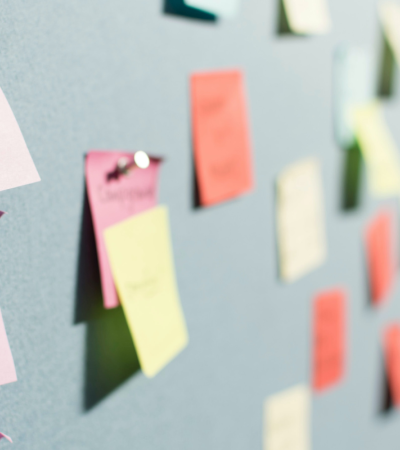 Photograph of multi-colored sticky note ideas pinned onto a board