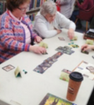 Group of older gamers playing a press your luck game "Incan Gold."