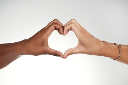 cropped photo of two women forming a heart with their hands