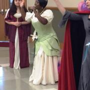 A woman dressed as Princess Tiana sings to the crowd.