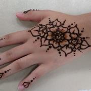 A participant shows off their hand with a completed henna design.