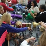 Participants use ribbon to create mesh wreaths. Participants use ribbon to create mesh wreaths.