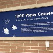 Photograph of the 1000 Paper Cranes table. The sign reads: 1000 Paper Cranes Hope & Support for Highland Park. In remembrance of the shooting in Highland Park last July, our library is sending thoughts of support to the Highland Park community.