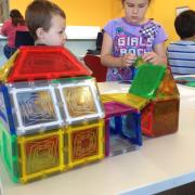 Two children build a house with Magna-Tiles