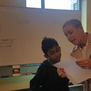 Adult shows child a piece of paper in the poetry workshop Adult shows child a piece of paper in the poetry workshop