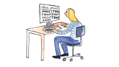 A cartoon drawing of a girl sitting at a desk in front of a computer that has the words "news update, fake, true" written across the screen.