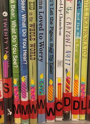 A group of books with birthday candle stickers affixed to their spines