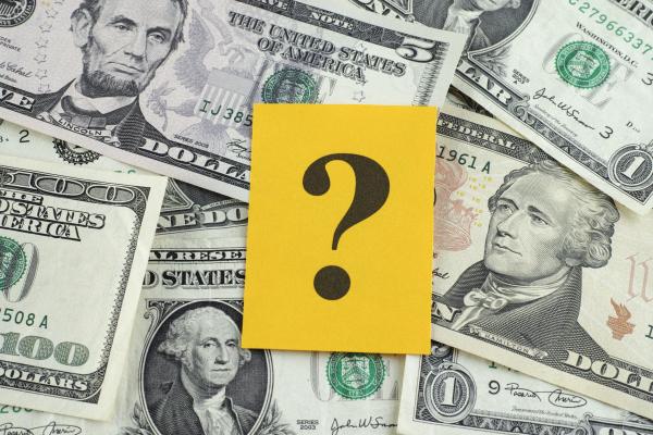 Photo of cash with a yellow question mark on top.