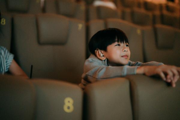 Photograph of a young child sitting and watching a performance