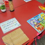 Photograph of a Manipulation Station table with a traceable alphabet game