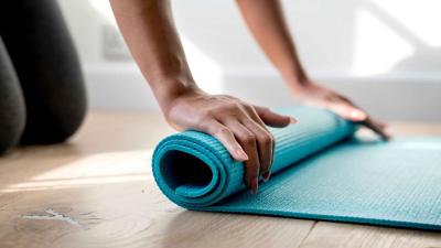 Woman rolling yoga mat